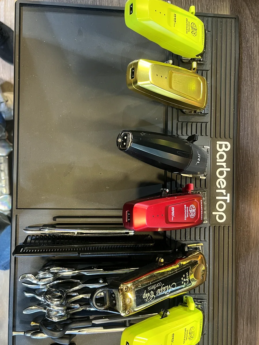 Clippers, trimmers and shears laid out on the barber mat